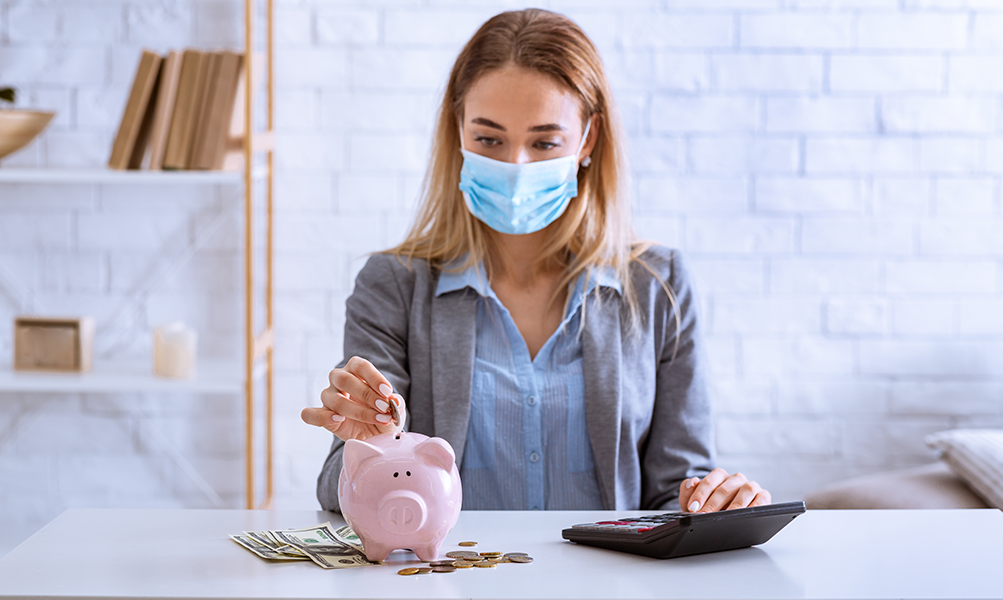 Woman in Mask Saving Money in piggy bank