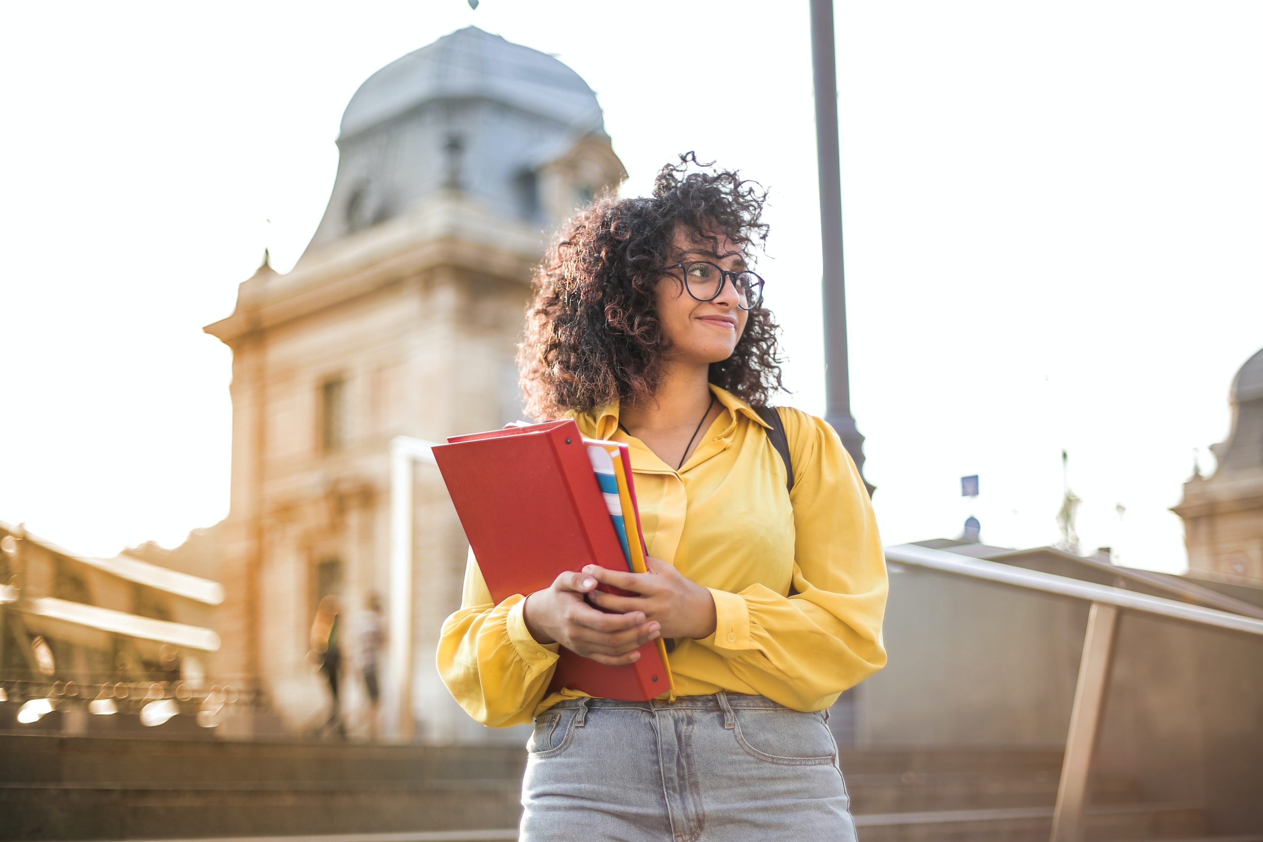 A college student standing proudly. If you're overwhelmed by the idea of saving for college, Trajan Wealth can help you out!