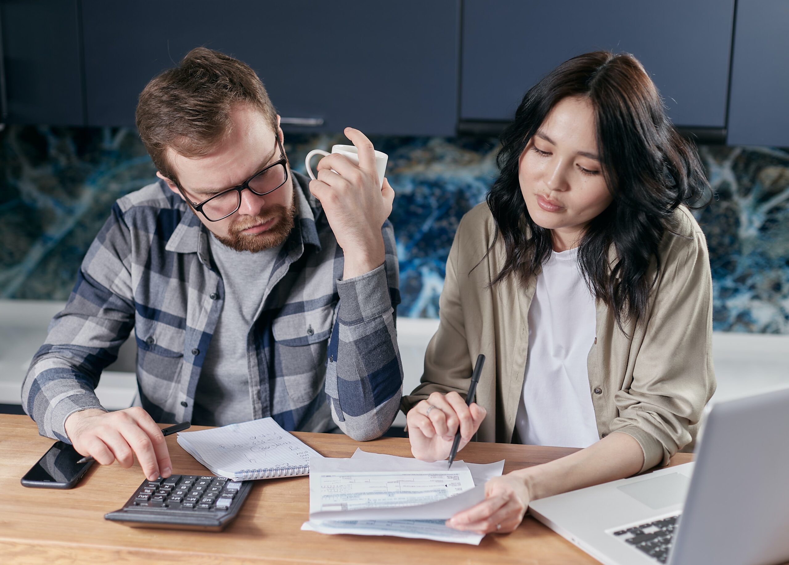 Two people looking puzzled at a piece of paper. Tackling credit card debt is one of the best steps you can take this year.