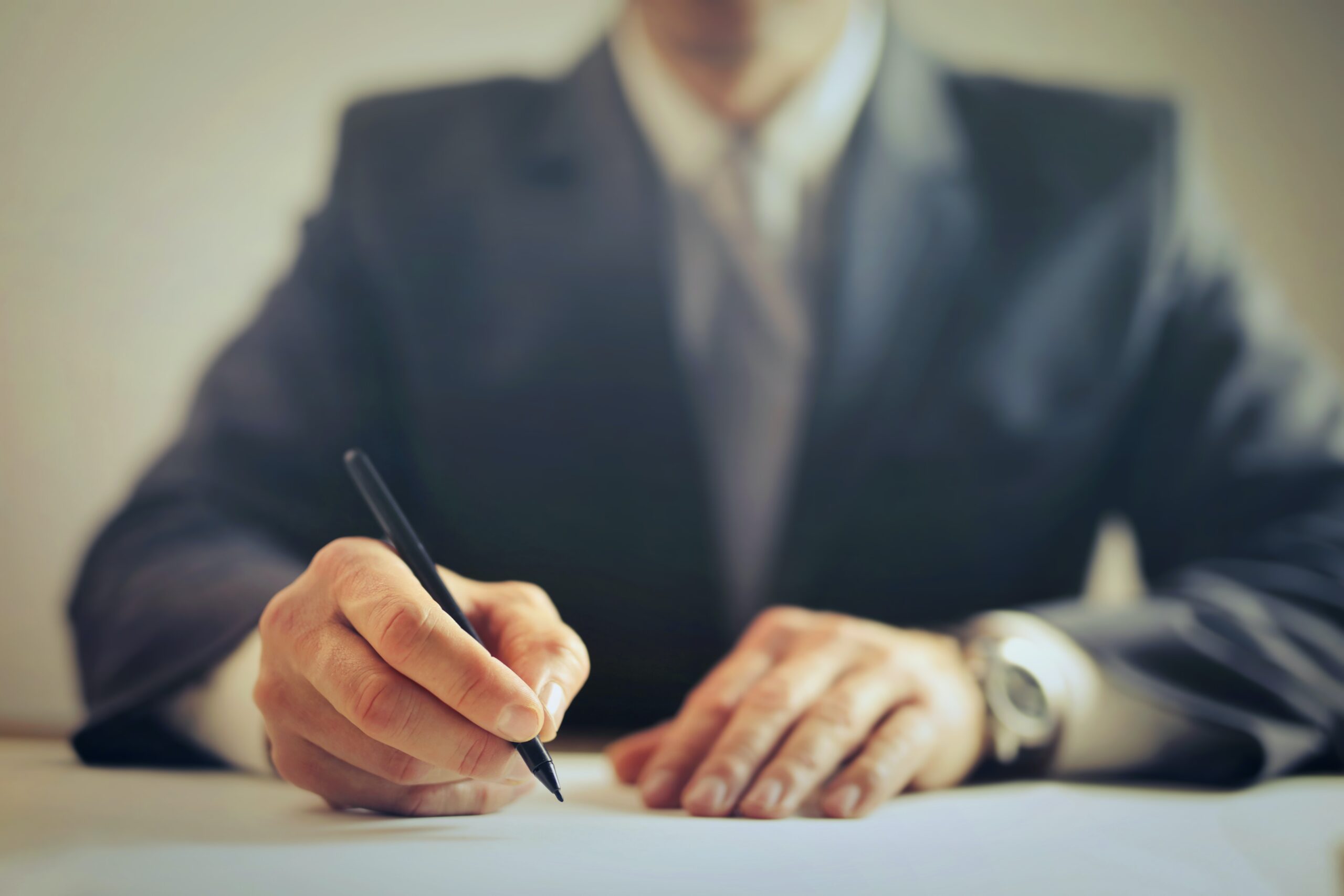 Man signing important document. Learn how asset protection is key to your financial future.
