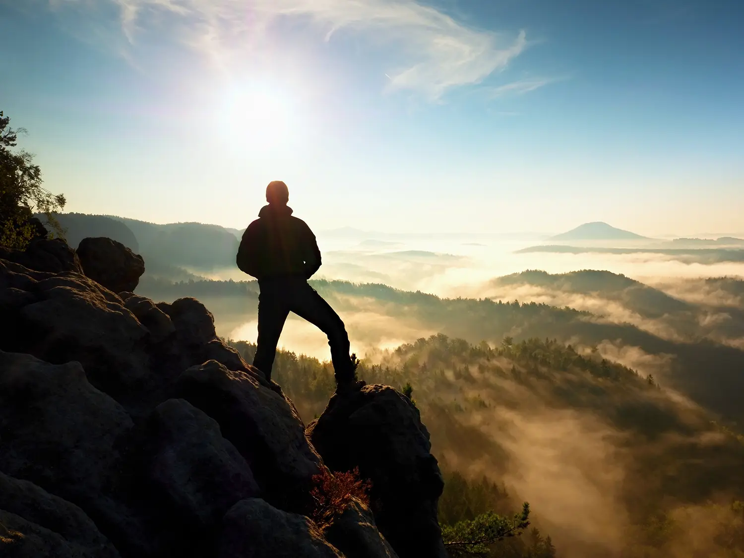 Hiker watching over the misty morning valley below